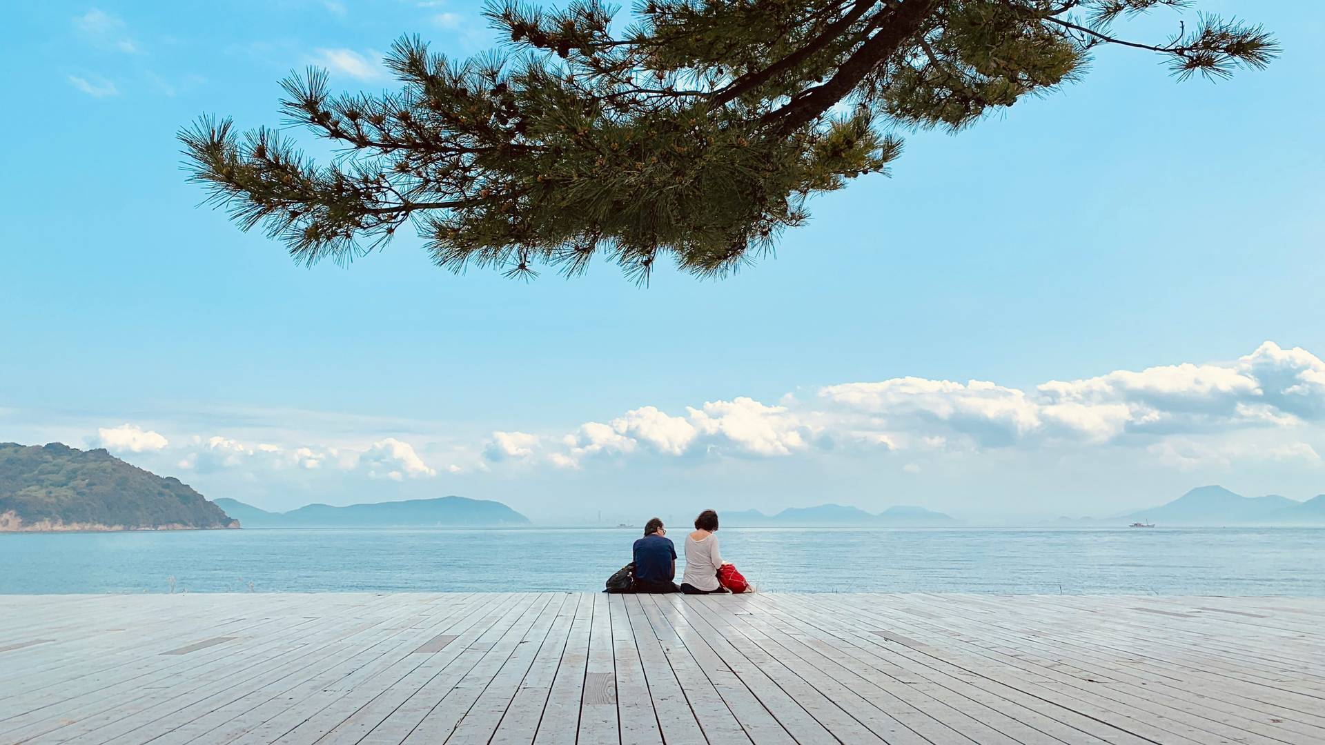 Twee reizigers kijken uit over de omgeving van Naoshima Island in Japan