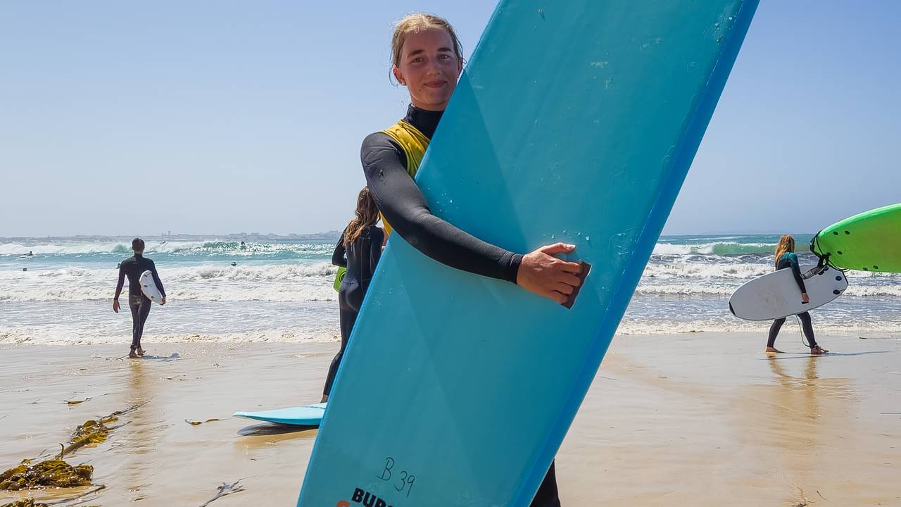 Meisje met surfplank op het strand