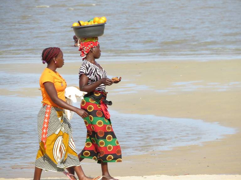 Vrouwen in kleurrijke kleding op het strand in Mozambique